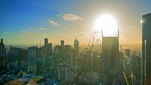 Aerial view of modern buildings in city against sky during sunset