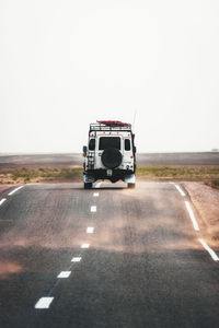 Vintage car on road against clear sky