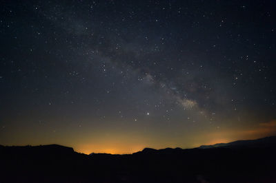 Low angle view of silhouette mountain against sky at night