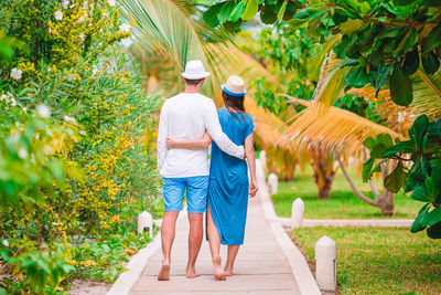 Rear view of people walking on plants