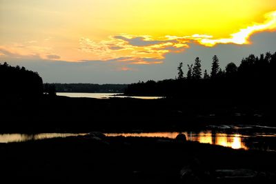 Scenic view of lake against sky at sunset
