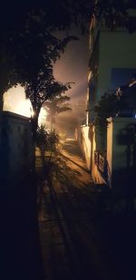 Street amidst buildings against sky at night