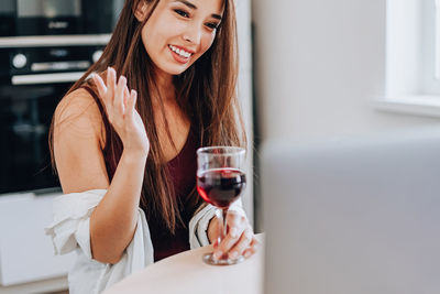 Smiling young woman sitting at home