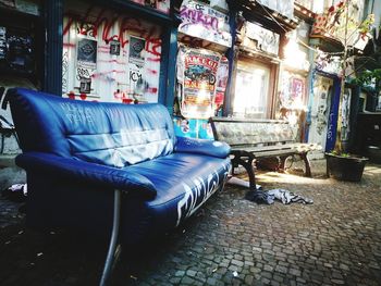 Empty chairs in street against building