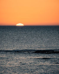 Scenic view of sea against orange sky