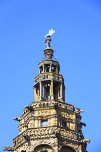 Low angle view of bell tower against blue sky