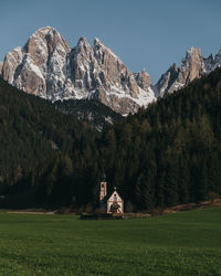 Built structure on field by mountain against sky