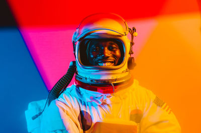 Portrait of man wearing multi colored umbrella