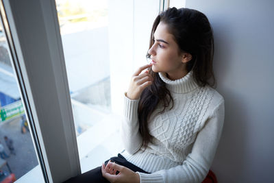 Young woman talking on phone at home