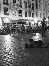 People on street by swimming pool in city at night