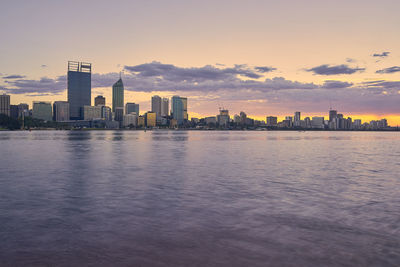 View of city at waterfront during sunset