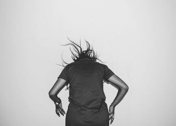 Rear view of woman standing against white background