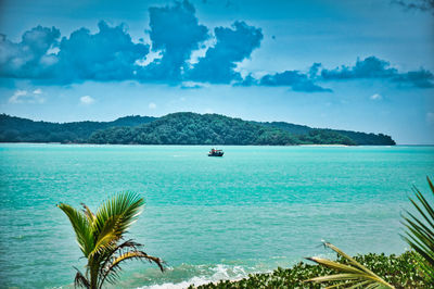 Speed boat on the waves of the azure andaman sea under the blue sky near the sandy beachshore