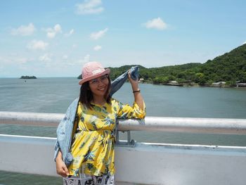 Woman standing by sea against sky