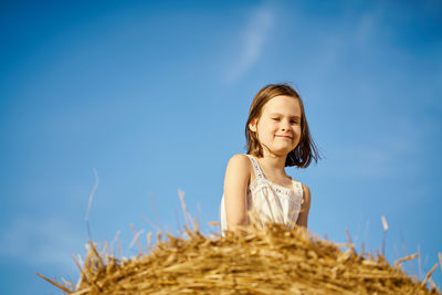 Portrait of smiling girl against blue sky