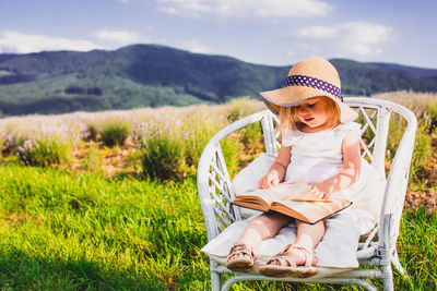 Full length of girl sitting on field