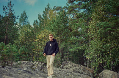 Portrait of smiling young woman standing in forest
