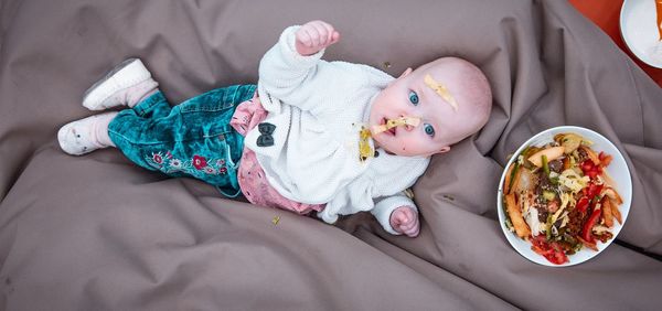 High angle view of baby lying on bed at home