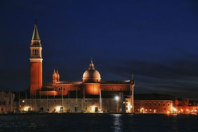 Illuminated buildings against sky at night