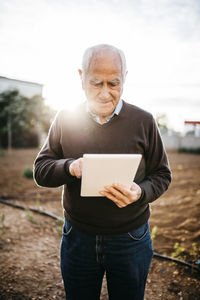 Senior man using tablet in the garden