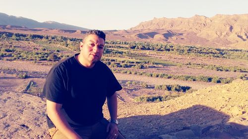 Man standing on arid landscape against sky