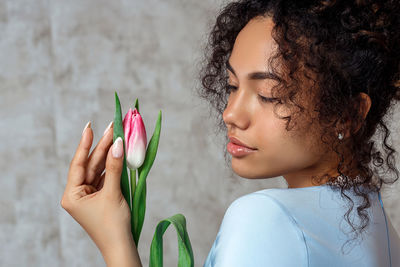 Close-up portrait of woman holding plant