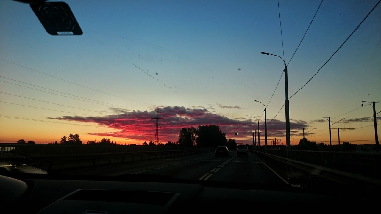 CARS ON ROAD IN CITY AGAINST SKY