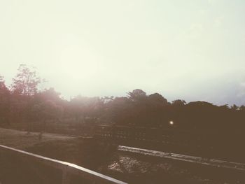 Road by trees against sky