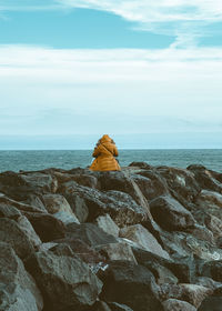 Rock formation on beach against sky