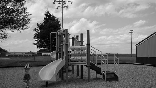 Boy playing on playground against sky