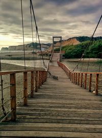 View of empty pier against cloudy sky