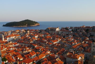 High angle view of town by sea against clear sky