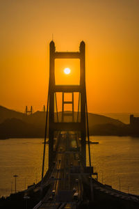 Low angle view of suspension bridge against sky during sunset