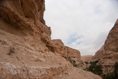 Low angle view of rocky mountains against sky