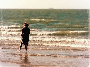 Rear view of man standing on beach