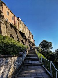 Low angle view of footpath against clear blue sky