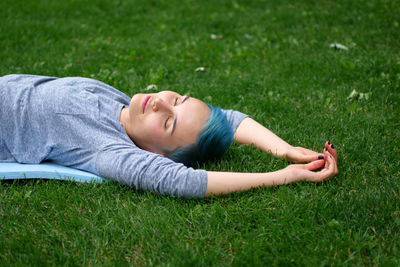 Young woman sleeping on grassy field