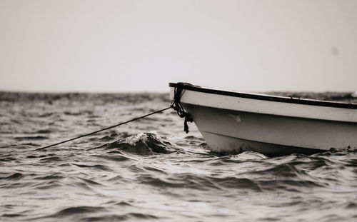 Fishing boat in sea against clear sky