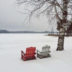 Empty chairs on snow covered ground