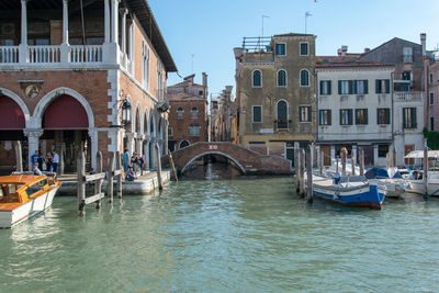 Boats in canal amidst buildings in city