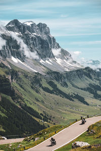 Scenic view of road by mountains against sky with motorcycle 