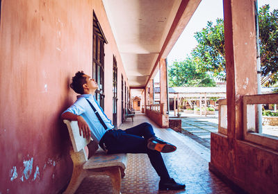 Man sitting on bench in corridor