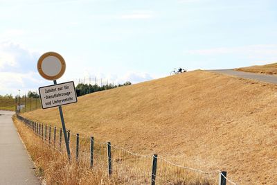 Road signs on landscape against sky