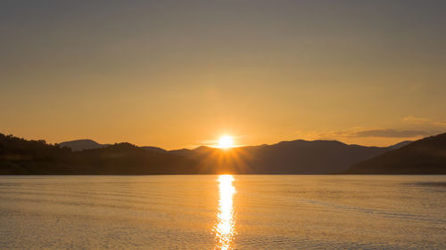 Scenic view of lake against romantic sky at sunset