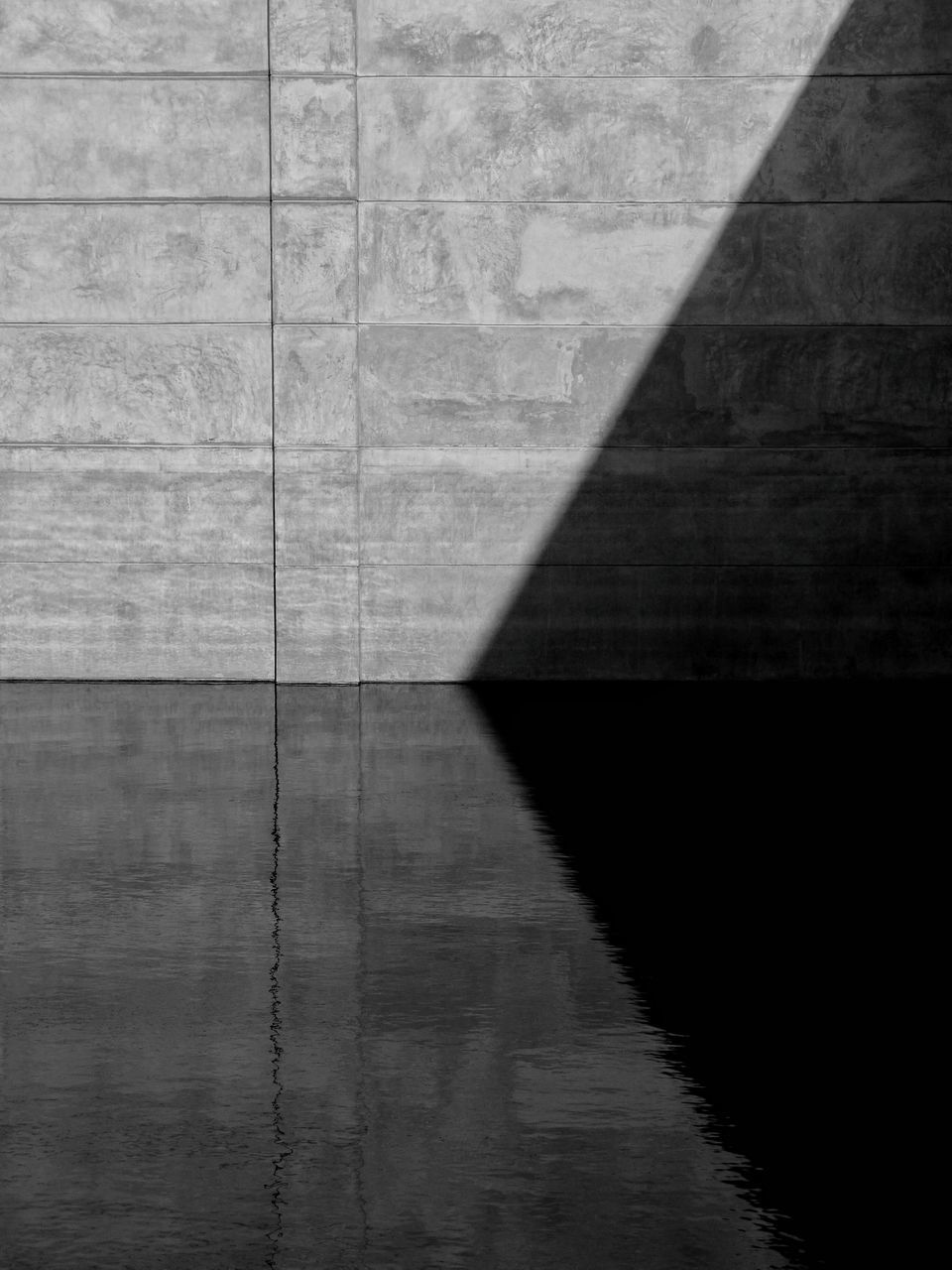 SHADOW OF CONCRETE WALL WITH REFLECTION