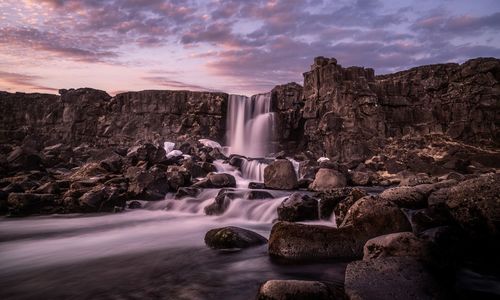 Scenic view of waterfall against sky