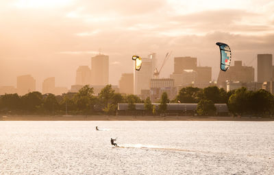 Scenic view of sea and buildings against sky during sunset