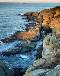 Rocks on sea shore against sky