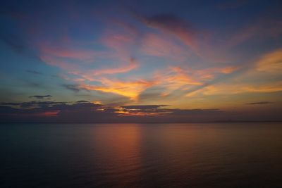 Scenic view of sea against dramatic sky during sunset