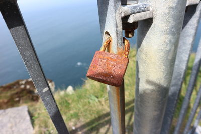 Close-up of rusty metal railing against sea